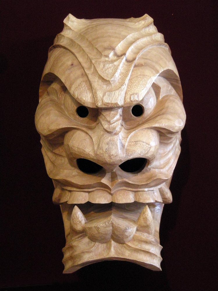 The female furyu mask in plain camphor: mouth open with fangs and tongue, upswept eyes, short horns