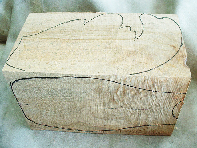 A camphor block with the outline of a mask drawn on it in ink