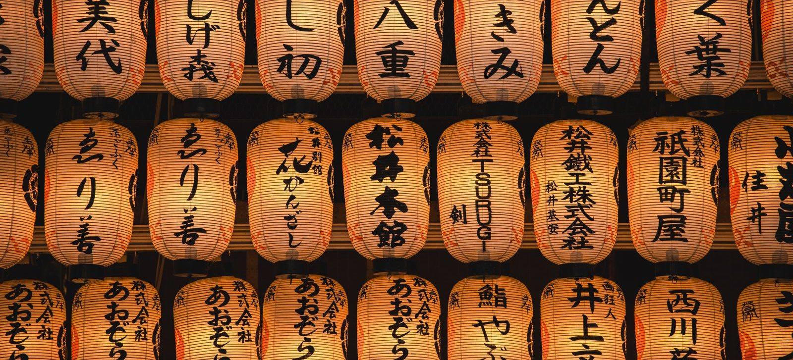 Rows of paper lanterns glowing at a Japanese festival at night