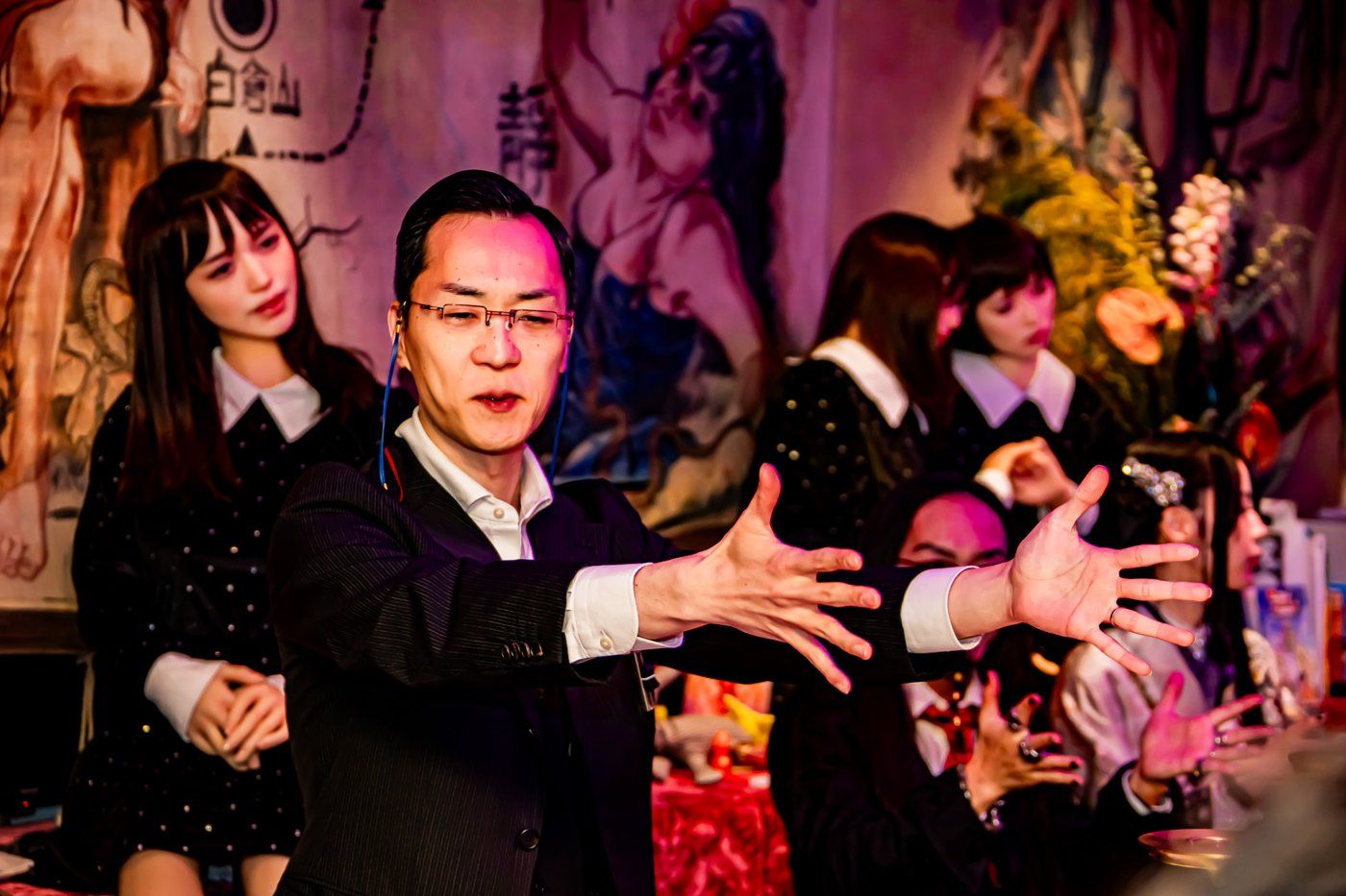 Shuhei Okawara performing before the sideshow banner mural, arms spread wide